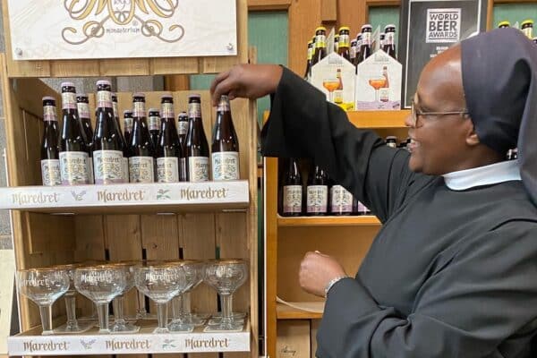 Une soeur qui montre des bières posées sur une étagère
