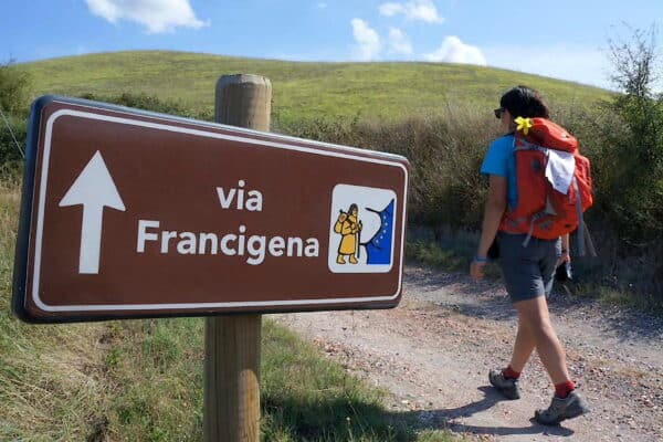 Une femme marche sur le chemin de la Via Francigena pour un pèlerinage