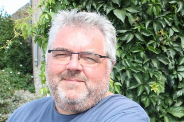 Photo portrait de Thierry Tilquin dans un jardin devant un buisson