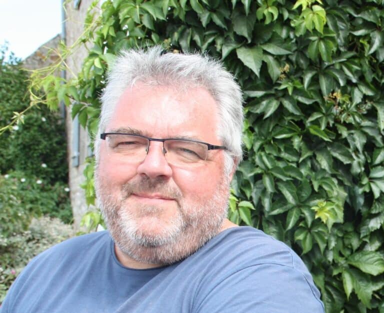 Photo portrait de Thierry Tilquin dans un jardin devant un buisson