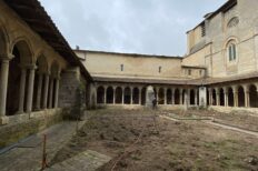 vue de l'intérieur de la cours d'une abbaye. La cours est en rénovation et quelqu'un travaille.