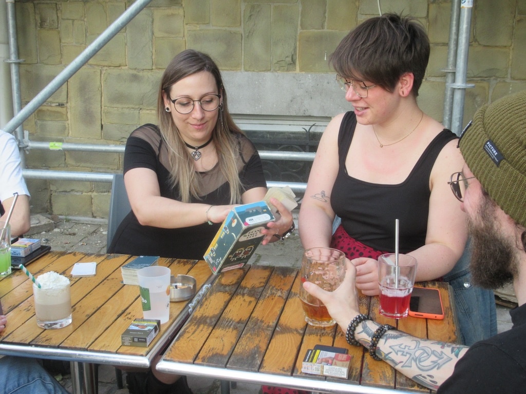 Femmes assises à une table jouant aux jeux de société et buvant des verres