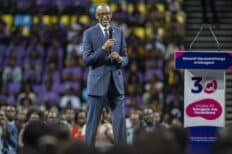 Paul Kagame debout sur une scène pour les élections devant une foule de personnes