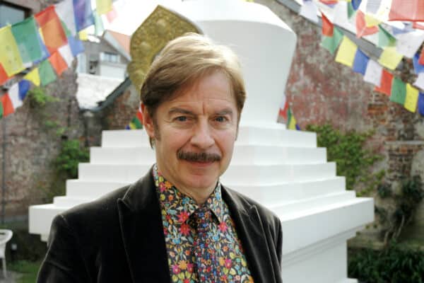 Carlo Luyck le représentant des Bouddhistes en Belgique devant un monument blanc