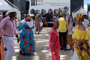 Des Guadeloupéens dansent et font la fête sur une place avec des tenues colorées