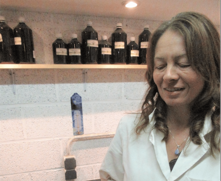 Nathalie Descurieux dans son atelier devant des bouteilles