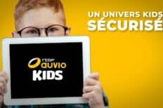 Un enfant tenant une pancarte où il est inscrit "Audio Kids" sur un fond jaune