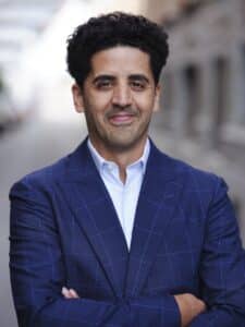 Photo portrait de Solayman Laqdim, les bras croisés, portant un costume bleu foncé et une chemise bleu claire