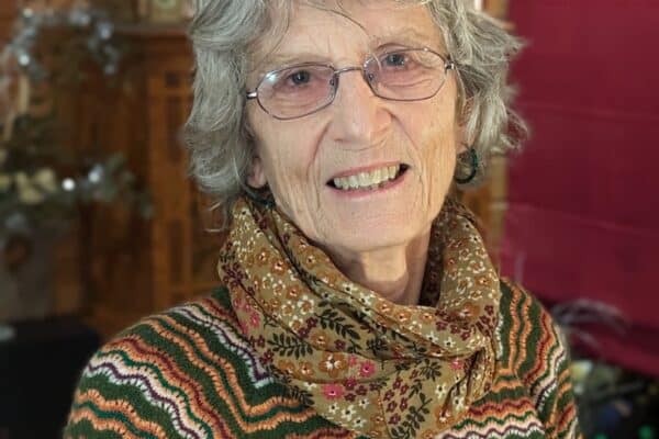 Thérèse Snoy portrait des lunettes et souriant à la caméra