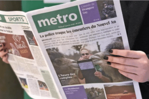 Mains féminines qui tiennent le journal Métro