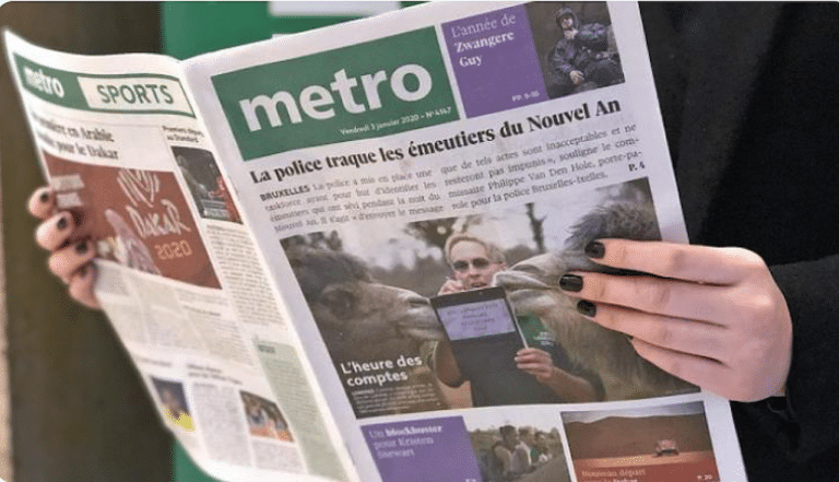 Mains féminines qui tiennent le journal Métro