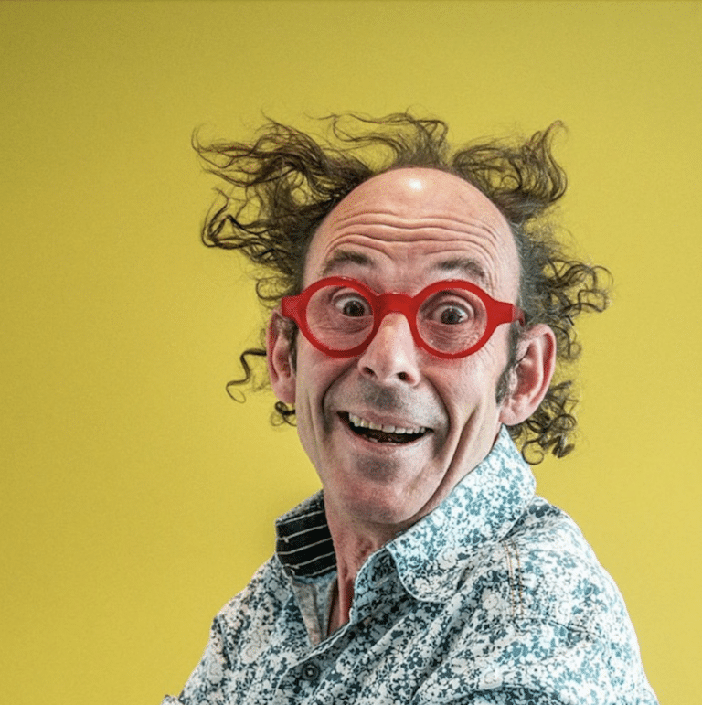 Vincent Pagé souriant à la caméra et portant des lunettes rouges