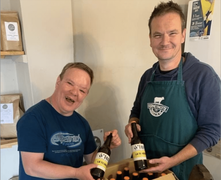 Deux personnes tenant des bouteilles de bière, l'une d'elle souffre d'un handicap mental