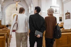 3 personnes marchant dans l'allée d'une église