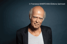 Portrait de Pascal Quignard devant un fond uni de couleur foncé