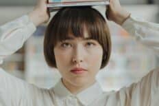 Une femme portant une pile de livre au dessus de la tête