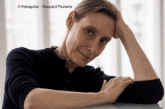 Photo de Michèle Anne de Mey accoudée sur une table en verre