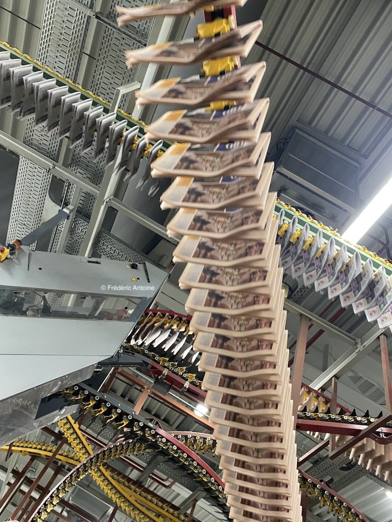 Plusieurs journaux papiers imprimés pendus à des machines qui servent à les imprimer