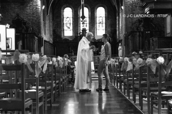 Intérieur d'une église avec un prêtre parlant avec une femme