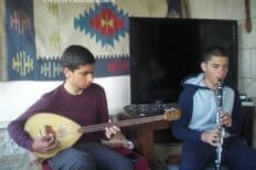 Enfants palestiniens dans une chambre, l'un joue de la guitare et l'autre de la flute