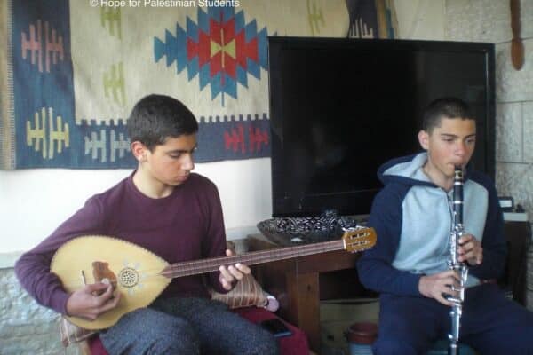 Enfants palestiniens dans une chambre, l'un joue de la guitare et l'autre de la flute