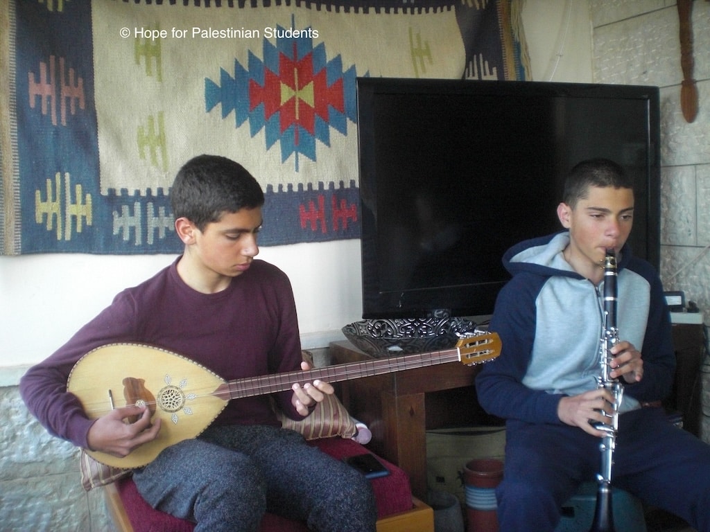 Enfants palestiniens dans une chambre, l'un joue de la guitare et l'autre de la flute