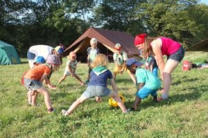 Des jeunes enfants jouent dans l'herbe avec une balle