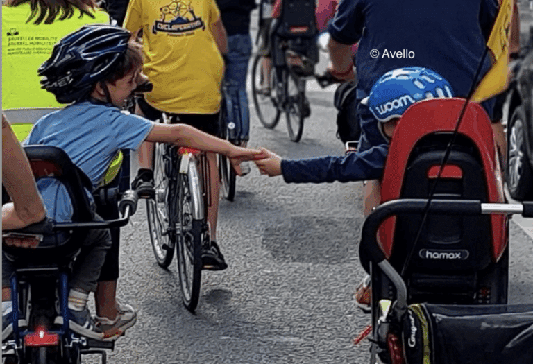 Deux enfants qui se donnent la main en faisant du vélo