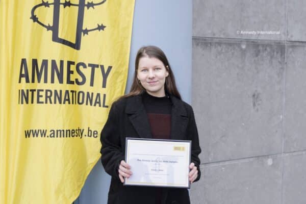 Une jeune fille devant un drapeau d'Amnesty International