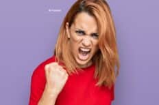 Jeune femme hispanique portant un t-shirt rouge en colère avec le point levé