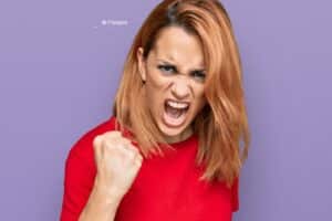 Jeune femme hispanique portant un t-shirt rouge en colère avec le point levé