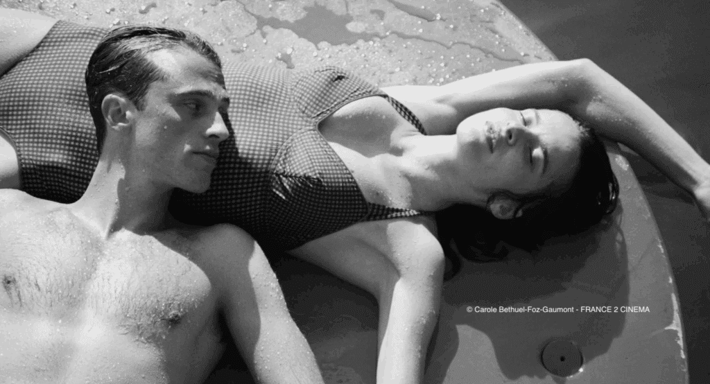 Photographie du film avec un homme et une femme couchés sur le sol en maillot de bain