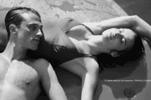 Photographie du film avec un homme et une femme couchés sur le sol en maillot de bain