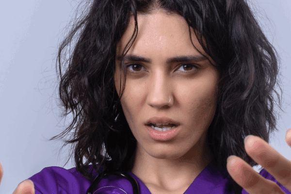 Une soignante met les mains devant elle comme pour se protéger