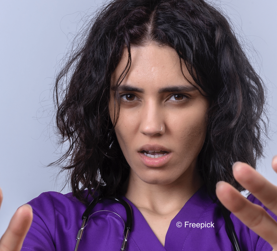 Une soignante met les mains devant elle comme pour se protéger