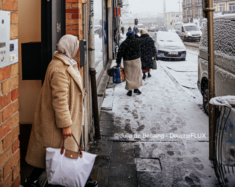 Une rue enneigée avec des silhouettes de personnes