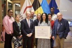 Une série de personnes qui tiennent un cadre dans lequel se tient un prix.