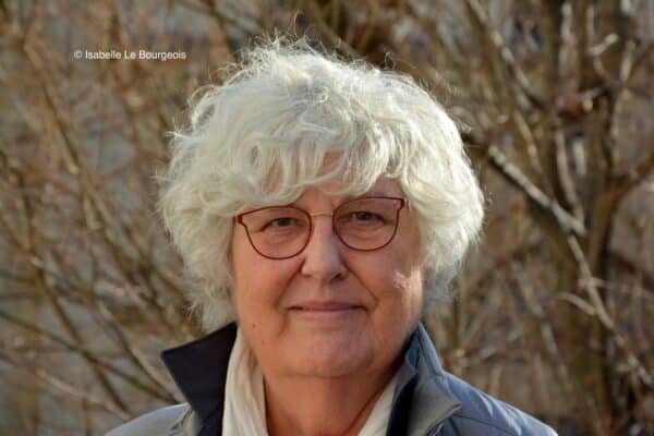 Photo d'Isabelle le Bourgeois à l'extérieur devant des branches d'arbres
