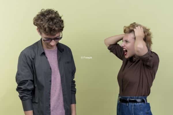 Une femme qui s'énerve sur un homme qui regarde vers le bas