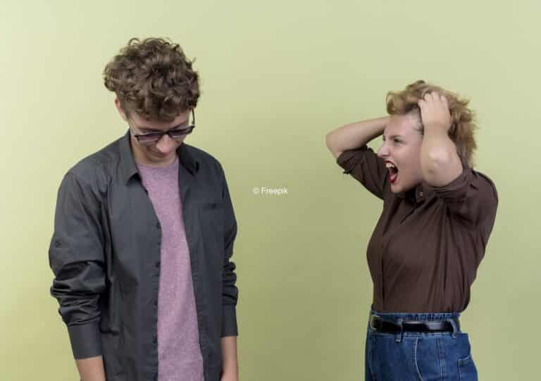 Une femme qui s'énerve sur un homme qui regarde vers le bas