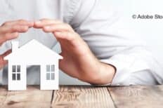 Une petite maisonnette en bois avec des mains autour