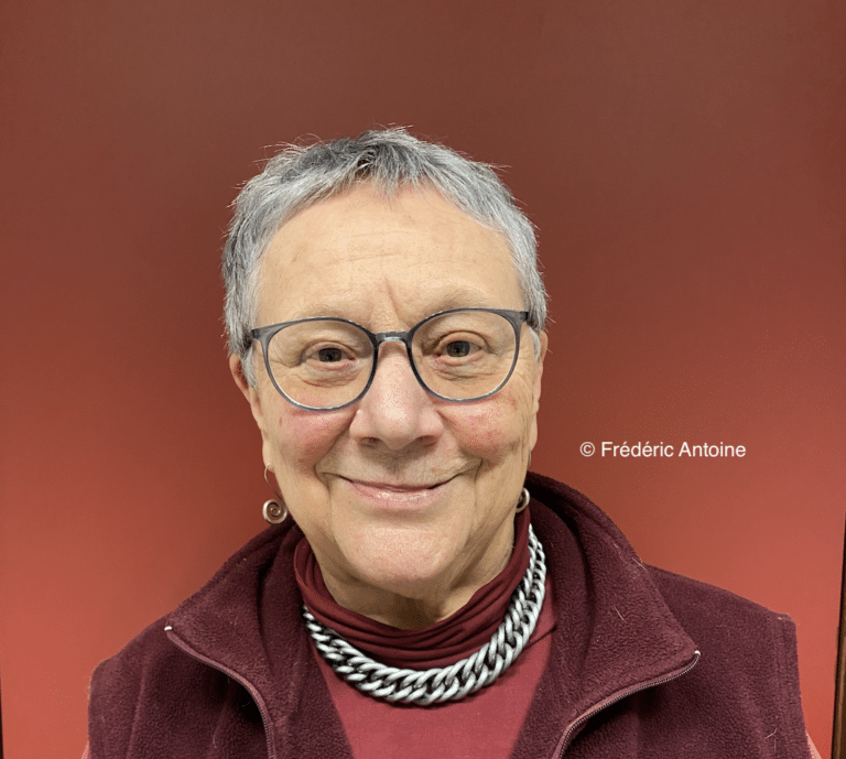 Portrait de Myriam Tonus devant un mur rouge