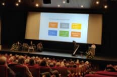 Conférence organisée par Rivespérance avec un tableau affiché et des personnes assises qui regardent