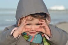 Un enfant avec les mains écartées autour des yeux