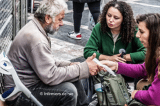 Deux jeunes femmes aux côtés d'un homme sans-abri