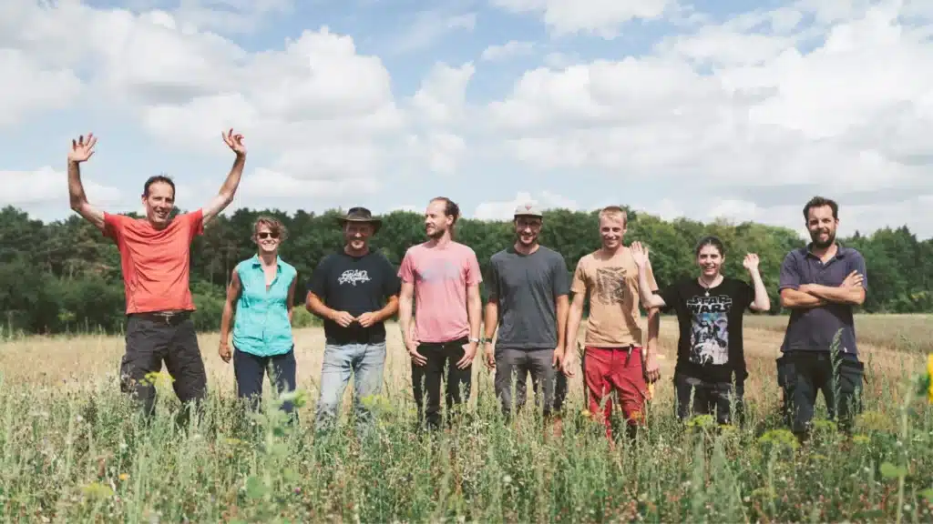 Membres de l'ASBL Terre-en-Vue dans un champ les uns à côté des autres