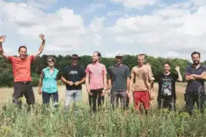 Membres de l'ASBL Terre-en-Vue dans un champ les uns à côté des autres