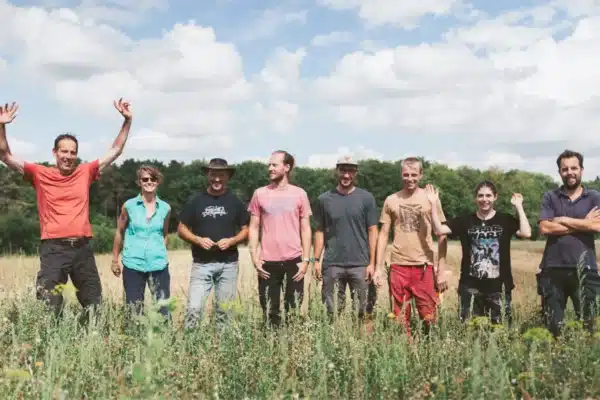Membres de l'ASBL Terre-en-Vue dans un champ les uns à côté des autres