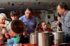 Des personnes réunies autour d'une table en train de cuisiner