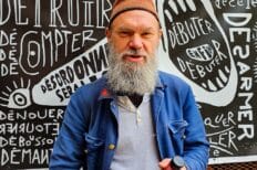 Photo de Timotéo Sergoï devant l'une de ses oeuvres